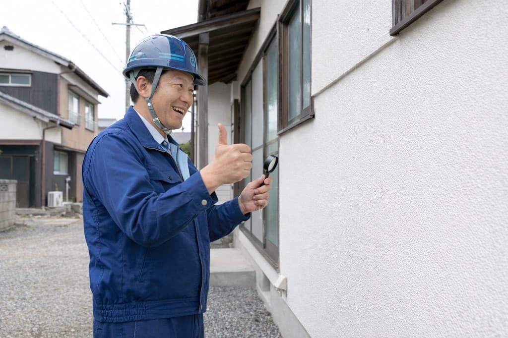 屋根と外壁の状態を点検する職人の写真